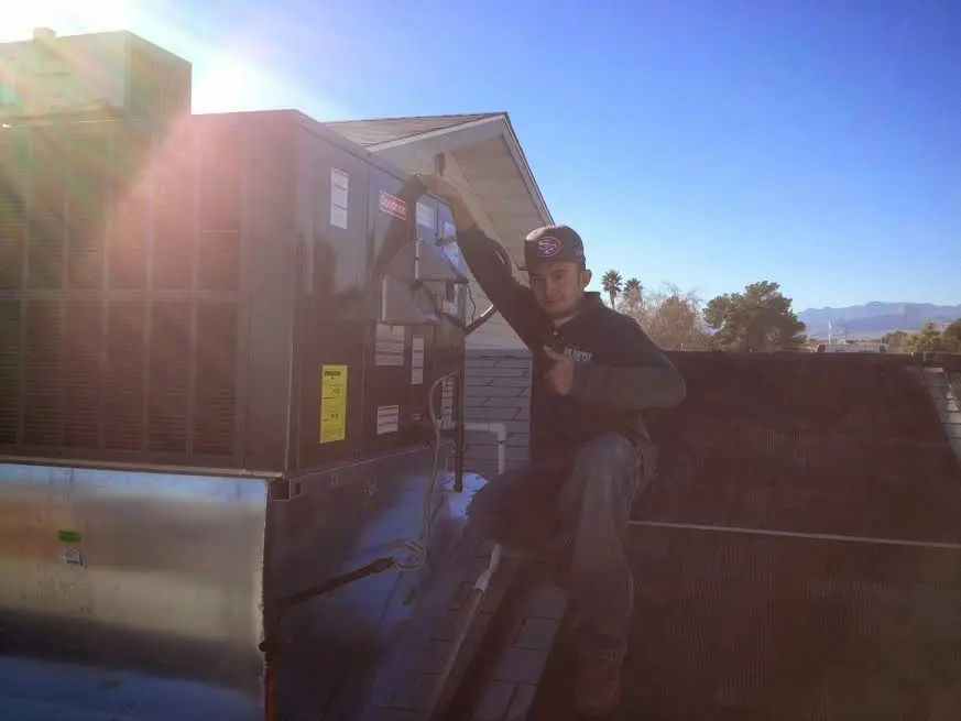 HVAC technician performing AC Tune-Up on a rooftop unit in Kenner